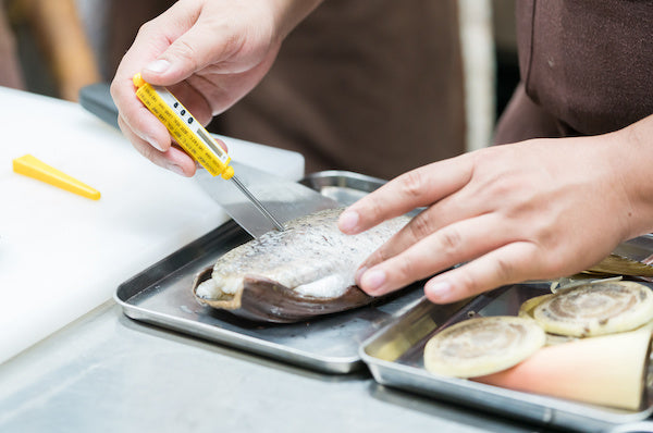 Checking a fish fillet for the proper internal temperature